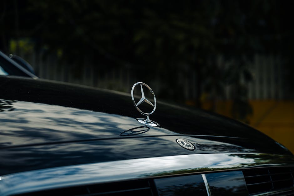 Close-up of a Mercedes emblem on a sleek black luxury car