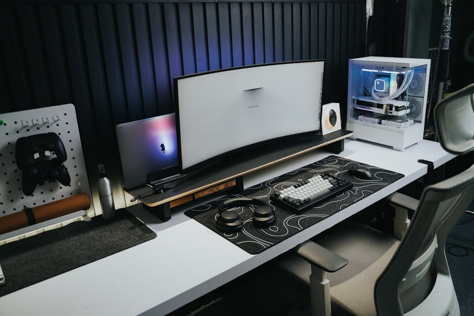 A sleek, modern office setup with a gaming PC, curved monitor, and accessories